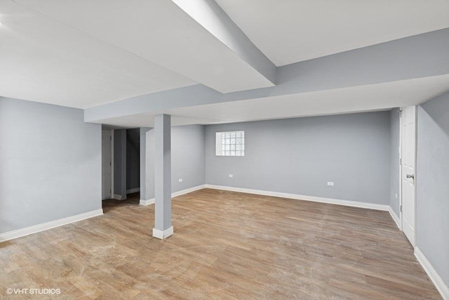 basement with baseboards and light wood-style floors