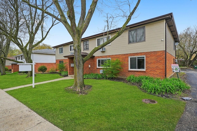traditional home featuring a front lawn and brick siding