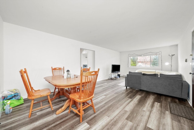 dining area with baseboards and wood finished floors