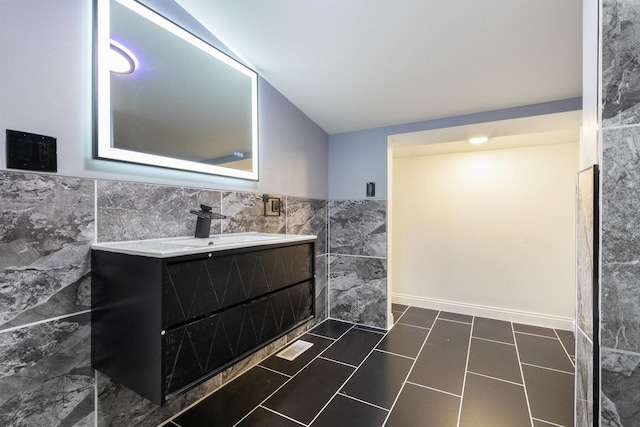 16910 Lincoln St, Hazel Crest, IL 60429 - bathroom featuring tile walls, vanity, vaulted ceiling, a wainscoted wall, and tile patterned flooring