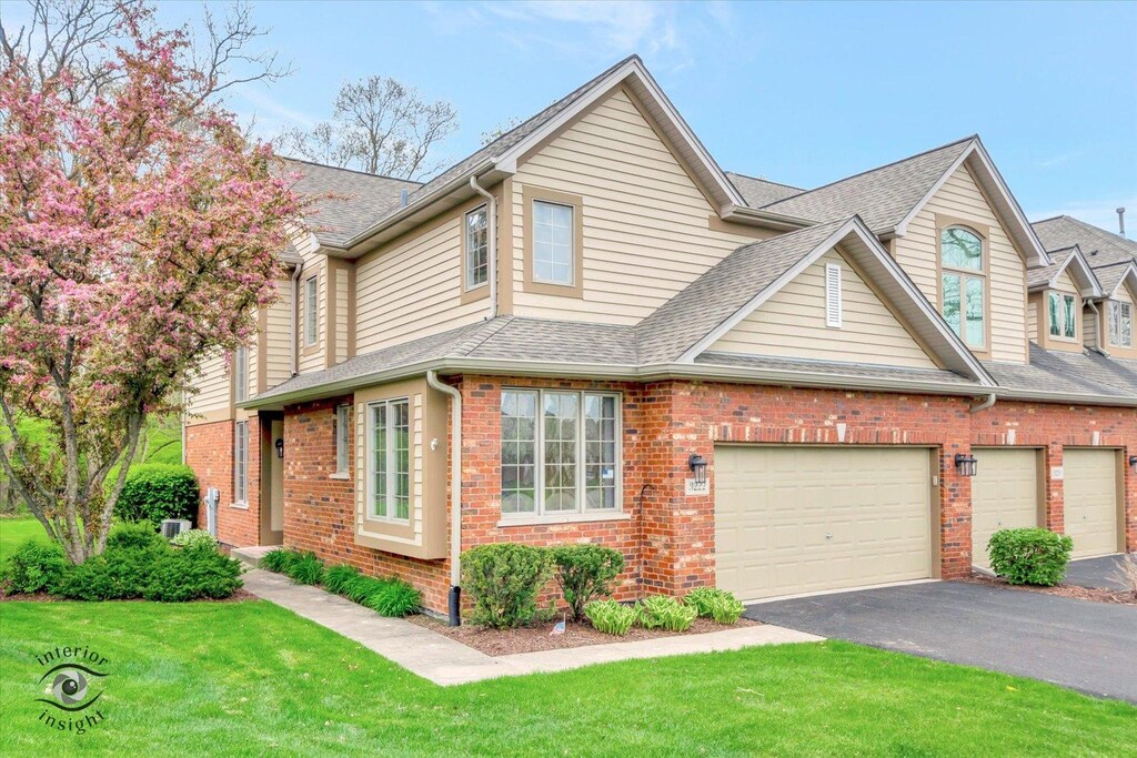 3222 Lightning Ct, New Lenox, IL 60451 - view of front facade featuring brick siding, a shingled roof, a front lawn, and aphalt driveway