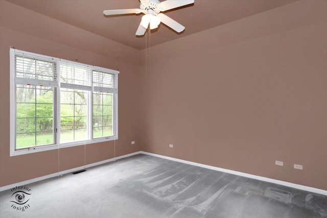 carpeted empty room with baseboards, a ceiling fan, and visible vents