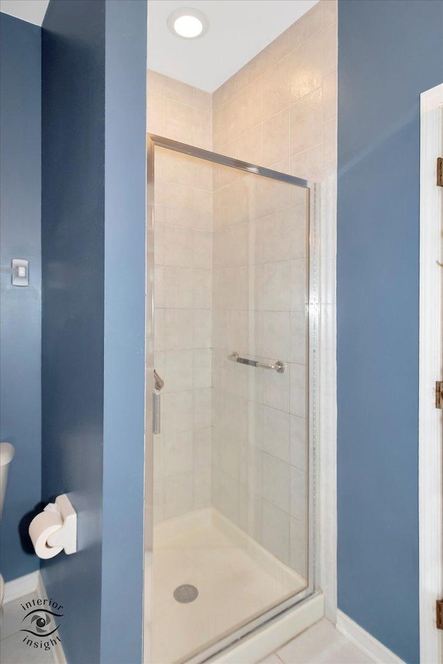 bathroom with baseboards and a shower stall