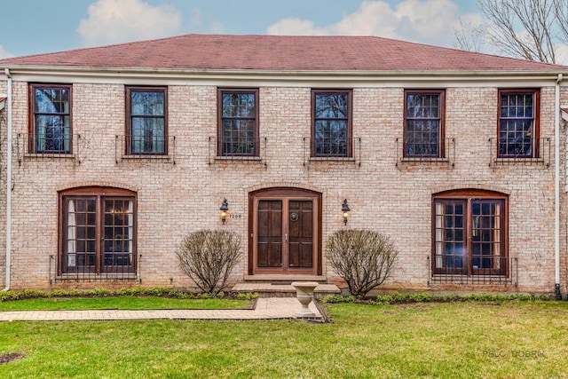 view of front of property with a front lawn and brick siding