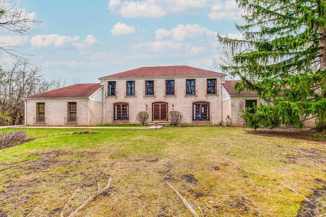 mediterranean / spanish-style home with brick siding, a front lawn, and french doors
