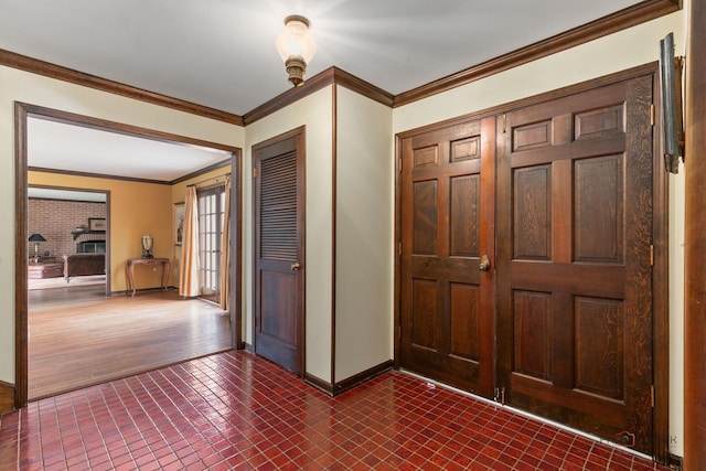foyer entrance featuring dark tile patterned floors, baseboards, and ornamental molding