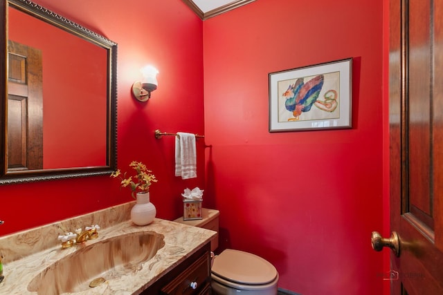 half bath featuring vanity and toilet