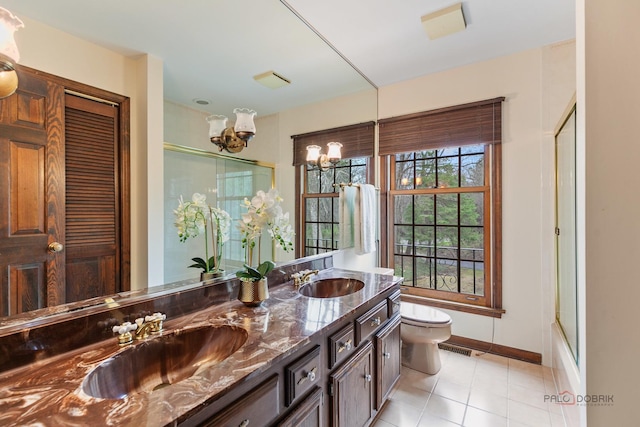 bathroom with baseboards, a sink, a chandelier, and toilet