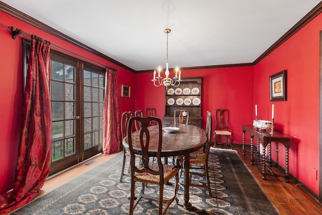 dining room featuring ornamental molding, a notable chandelier, wood finished floors, and a wealth of natural light