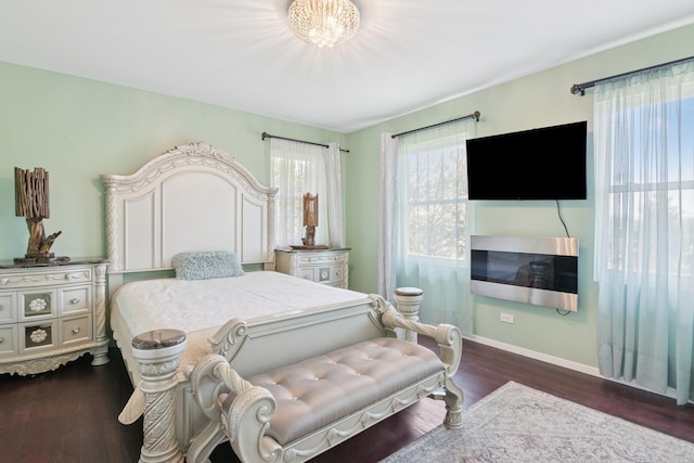 bedroom with baseboards and dark wood-type flooring