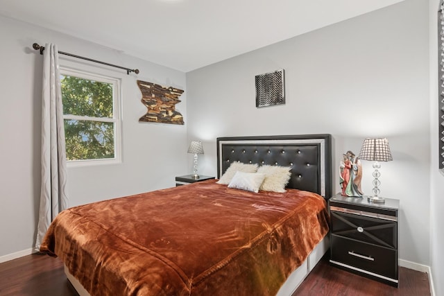 bedroom featuring baseboards and dark wood-style flooring