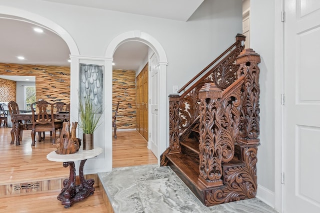 foyer with recessed lighting, arched walkways, decorative columns, and wood finished floors