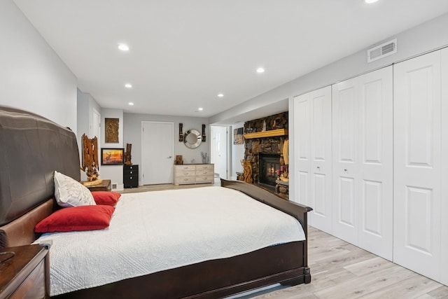 bedroom featuring recessed lighting, a fireplace, light wood-type flooring, and visible vents