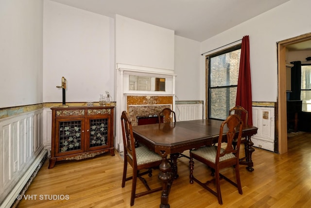 3912 S Prairie Ave, Chicago, IL 60653 - dining space featuring a baseboard radiator, light wood-type flooring, and wainscoting
