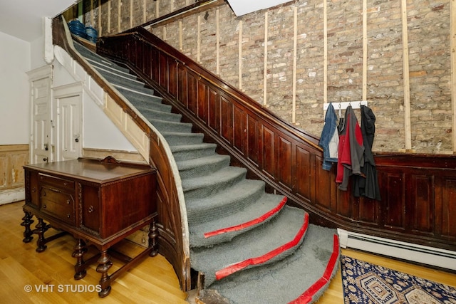 3912 S Prairie Ave, Chicago, IL 60653 - stairs featuring a wainscoted wall, wood finished floors, a baseboard radiator, and wooden walls