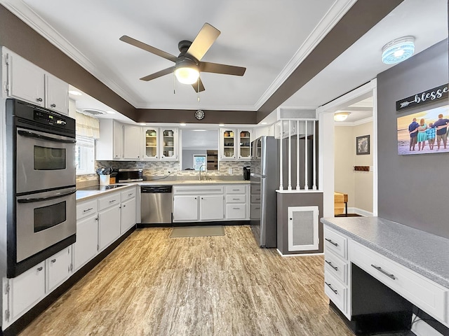 1402 W Lincoln Blvd, Freeport, IL 61032 - kitchen with appliances with stainless steel finishes, ornamental molding, ceiling fan, light wood-style floors, and backsplash
