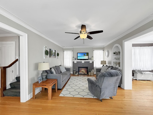 1402 W Lincoln Blvd, Freeport, IL 61032 - living room featuring radiator heating unit, a ceiling fan, stairway, light wood finished floors, and ornamental molding