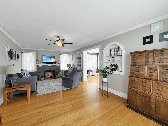 1402 W Lincoln Blvd, Freeport, IL 61032 - living area featuring light wood-style floors, crown molding, ceiling fan, and a brick fireplace