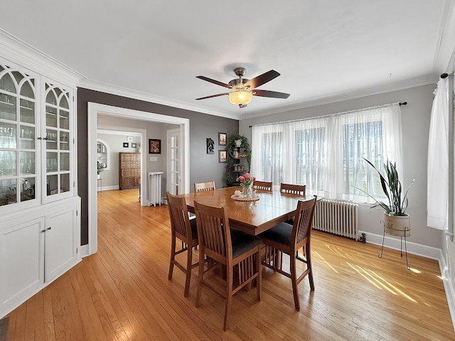 1402 W Lincoln Blvd, Freeport, IL 61032 - dining space featuring radiator, crown molding, a ceiling fan, and light wood finished floors