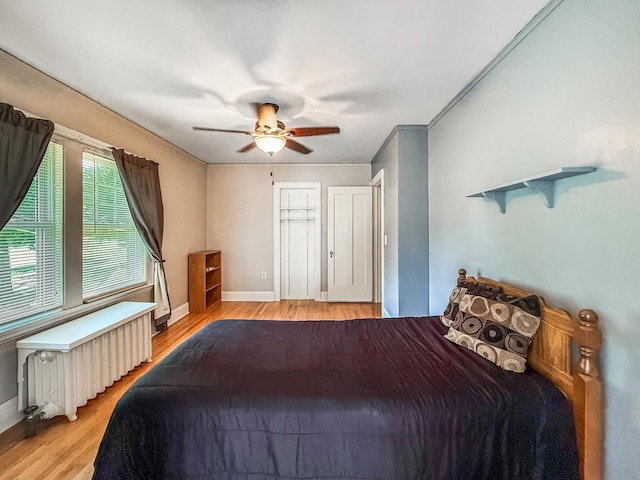 1402 W Lincoln Blvd, Freeport, IL 61032 - bedroom featuring radiator heating unit, light wood-style floors, and a ceiling fan