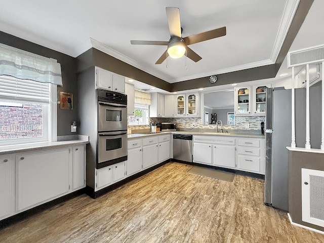 1402 W Lincoln Blvd, Freeport, IL 61032 - kitchen with appliances with stainless steel finishes, a ceiling fan, crown molding, glass insert cabinets, and backsplash