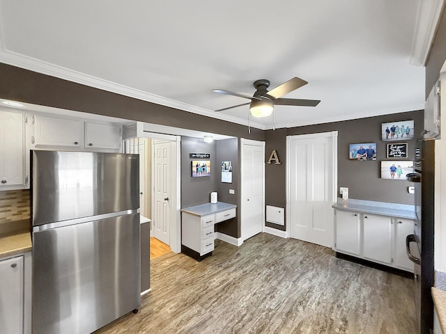 1402 W Lincoln Blvd, Freeport, IL 61032 - kitchen featuring freestanding refrigerator, light wood-type flooring, a ceiling fan, light countertops, and white cabinets
