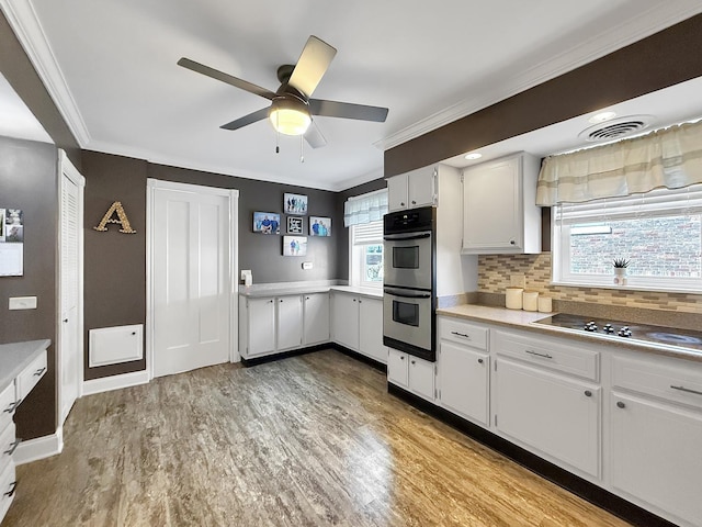 1402 W Lincoln Blvd, Freeport, IL 61032 - kitchen featuring ornamental molding, double oven, light countertops, a ceiling fan, and electric cooktop