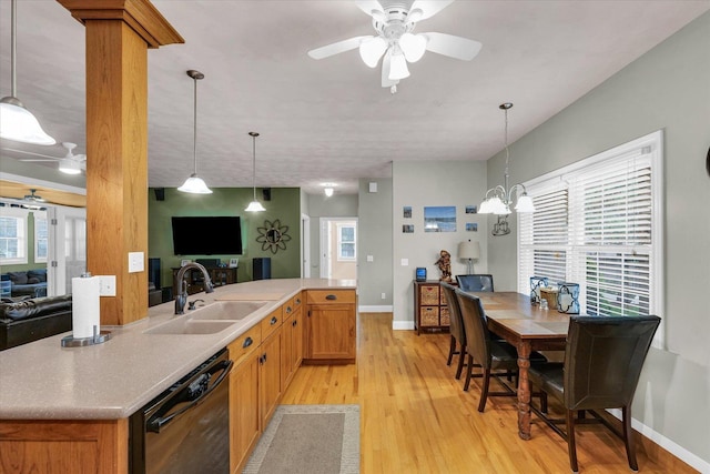 kitchen with baseboards, open floor plan, black dishwasher, a sink, and light wood finished floors