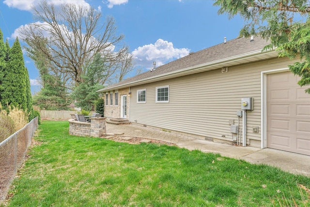 back of house with fence, a lawn, and a garage
