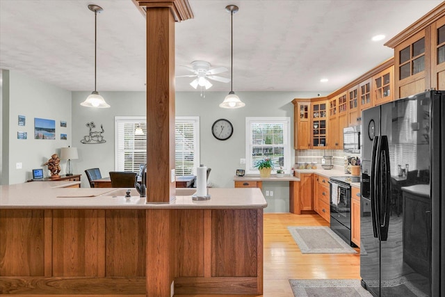 kitchen with ceiling fan, light wood-style floors, light countertops, decorative light fixtures, and black appliances