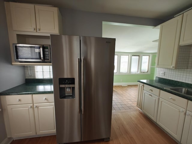 3114 N Long Ave, Chicago, IL 60641 - kitchen with stainless steel fridge, white cabinets, dark countertops, and tasteful backsplash