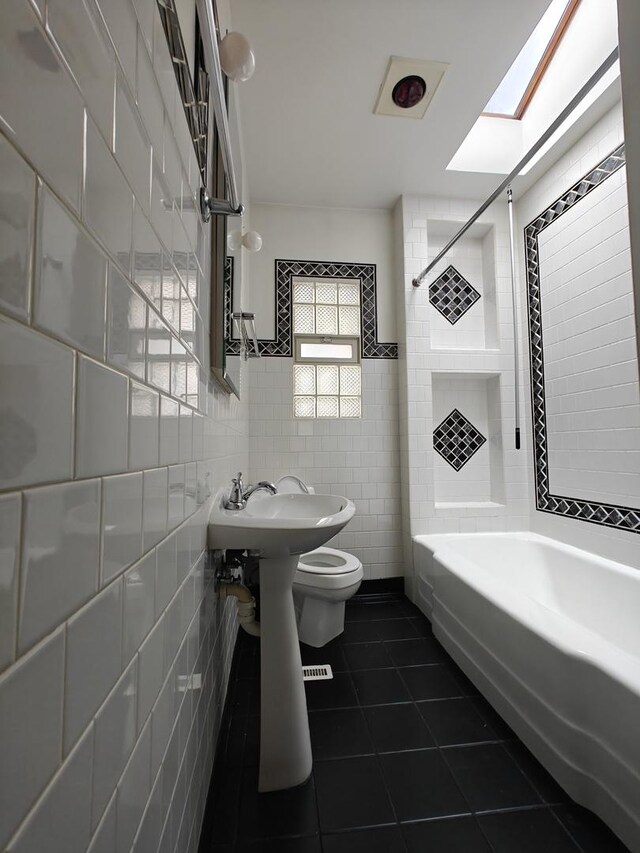 3114 N Long Ave, Chicago, IL 60641 - bathroom with toilet, tile walls, shower / tub combination, tile patterned floors, and a sink