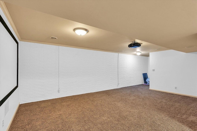 carpeted cinema room with baseboards and brick wall