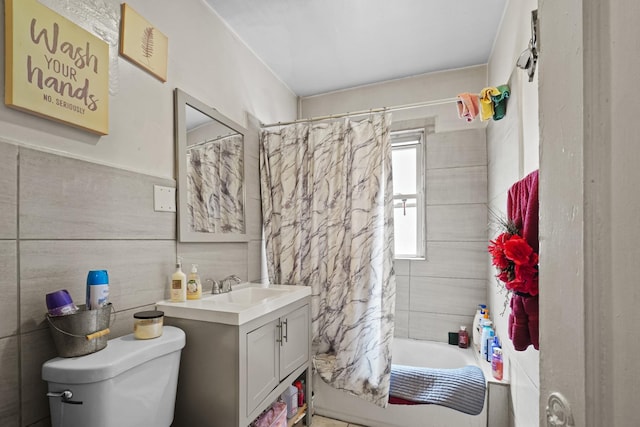 full bathroom with vanity, shower / bath combo, toilet, and tile walls