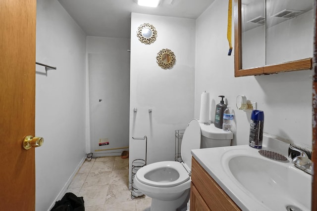 bathroom featuring toilet, baseboards, and vanity