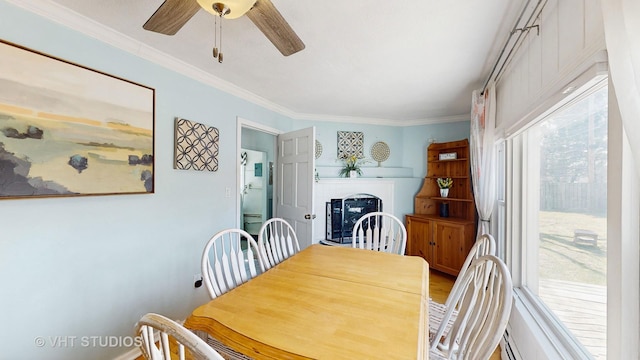 dining room with crown molding, ceiling fan, and a fireplace