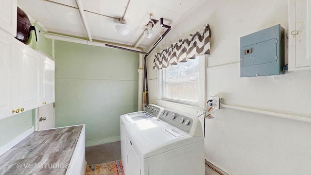 clothes washing area with washer and clothes dryer, cabinet space, and electric panel