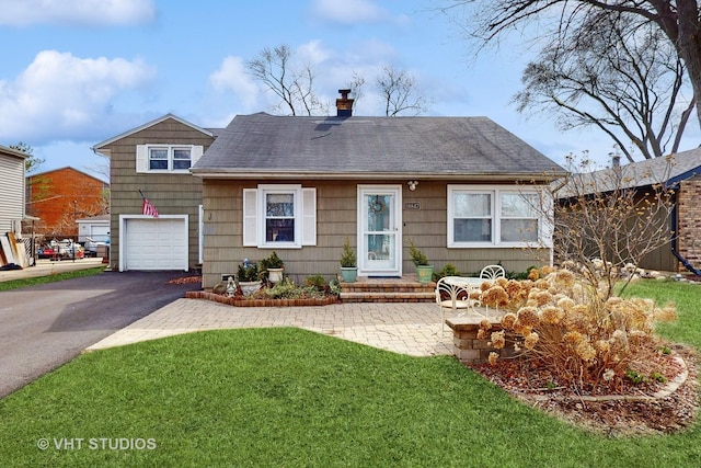 view of front of property featuring a garage, a front lawn, aphalt driveway, a chimney, and a shingled roof