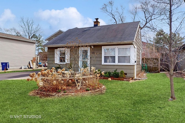 view of front of house featuring crawl space, a front yard, a chimney, and roof with shingles