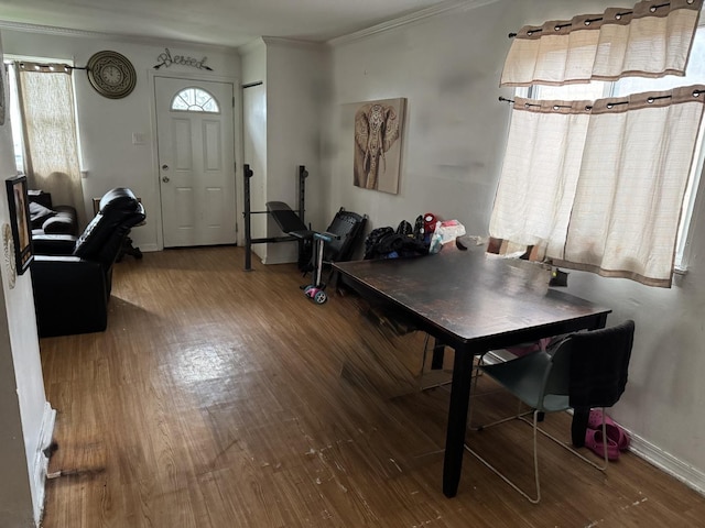 dining area with crown molding, baseboards, and wood finished floors