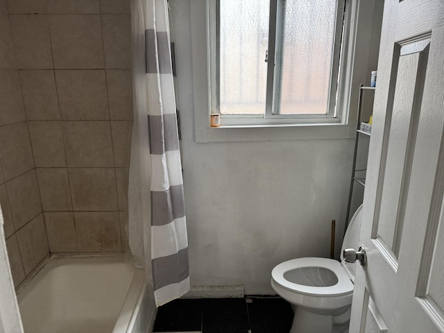 bathroom with tile patterned flooring, shower / tub combo, and toilet