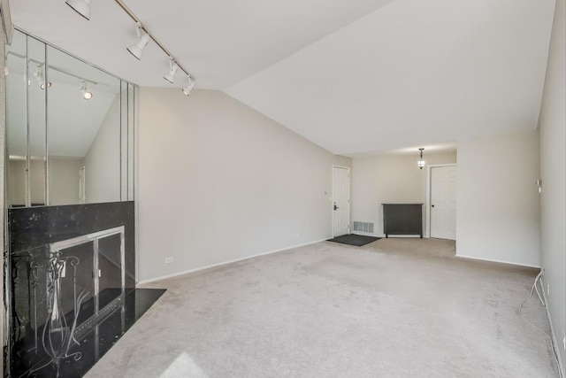 1608 Pennsbury Ct Unit A2, Wheeling, IL 60090 - unfurnished living room featuring lofted ceiling, rail lighting, carpet, and baseboards