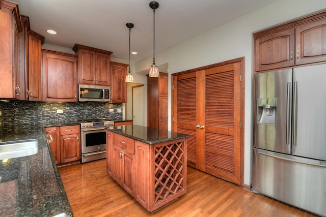 kitchen featuring a center island, light wood-type flooring, tasteful backsplash, a sink, and stainless steel appliances