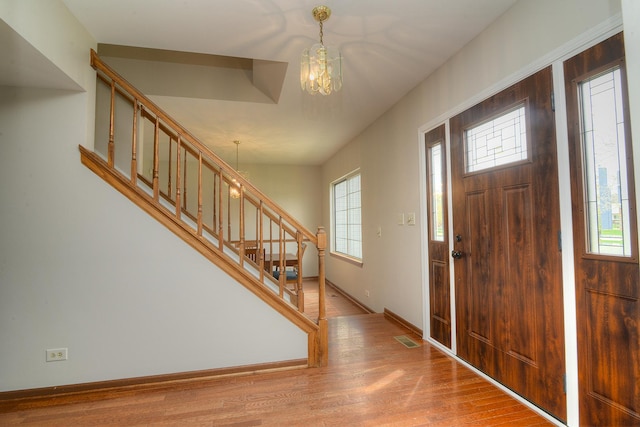 entrance foyer with a notable chandelier, a healthy amount of sunlight, and stairway