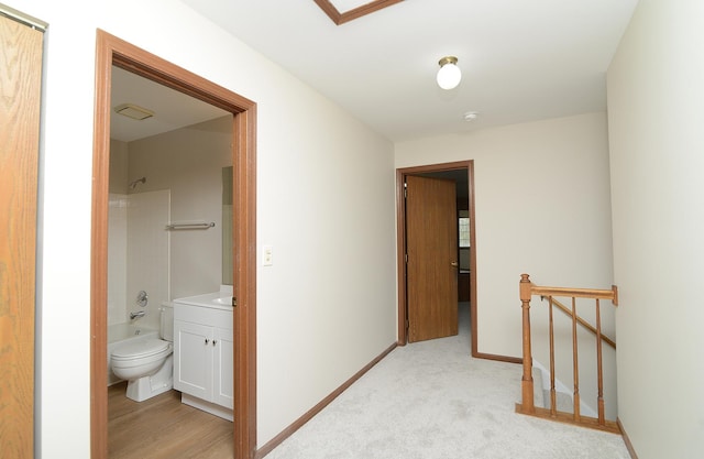 hall with baseboards and an upstairs landing
