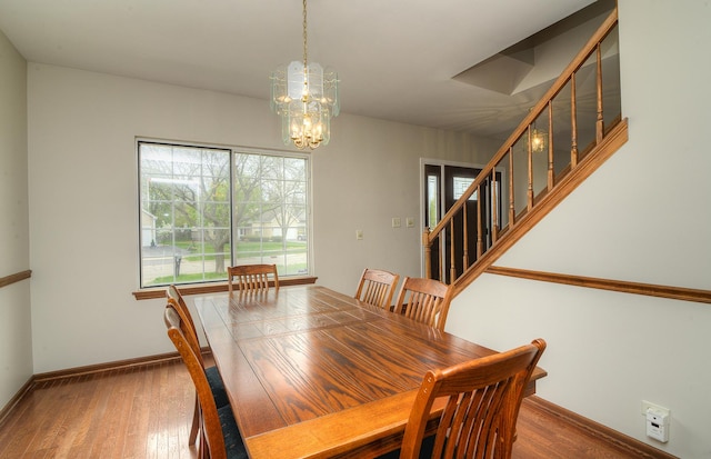 dining space with stairway, baseboards, wood finished floors, and a notable chandelier