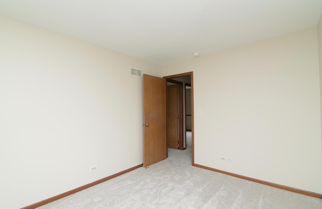 unfurnished room with baseboards, visible vents, and light colored carpet