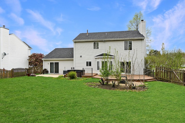 back of property featuring a lawn, a chimney, and a fenced backyard