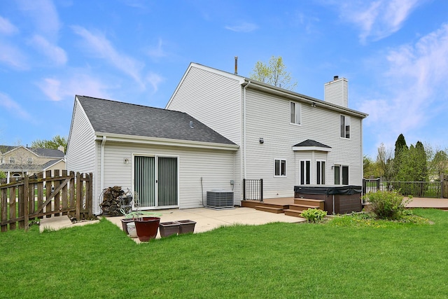 rear view of property with a patio, a hot tub, fence, and a chimney