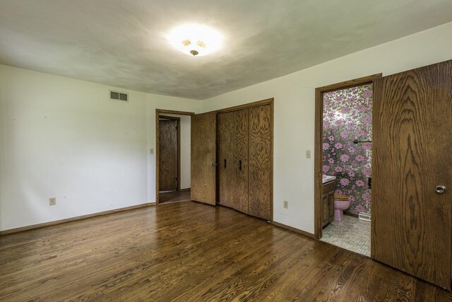 301 Garnett Ave, Winthrop Harbor, IL 60096 - unfurnished bedroom featuring wood finished floors, baseboards, a closet, and ensuite bath